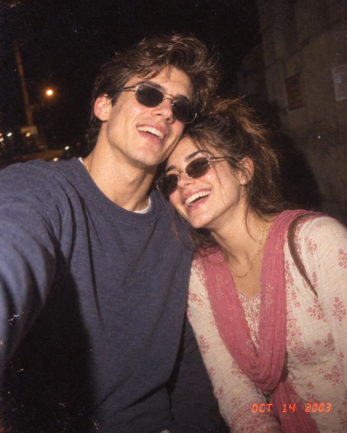 Couple laughing at night lit by a harsh disposable camera flash