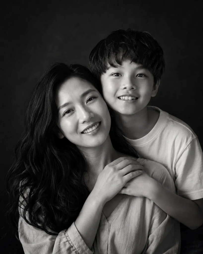 Fine-art black and white portrait of a mother and son with joined hands