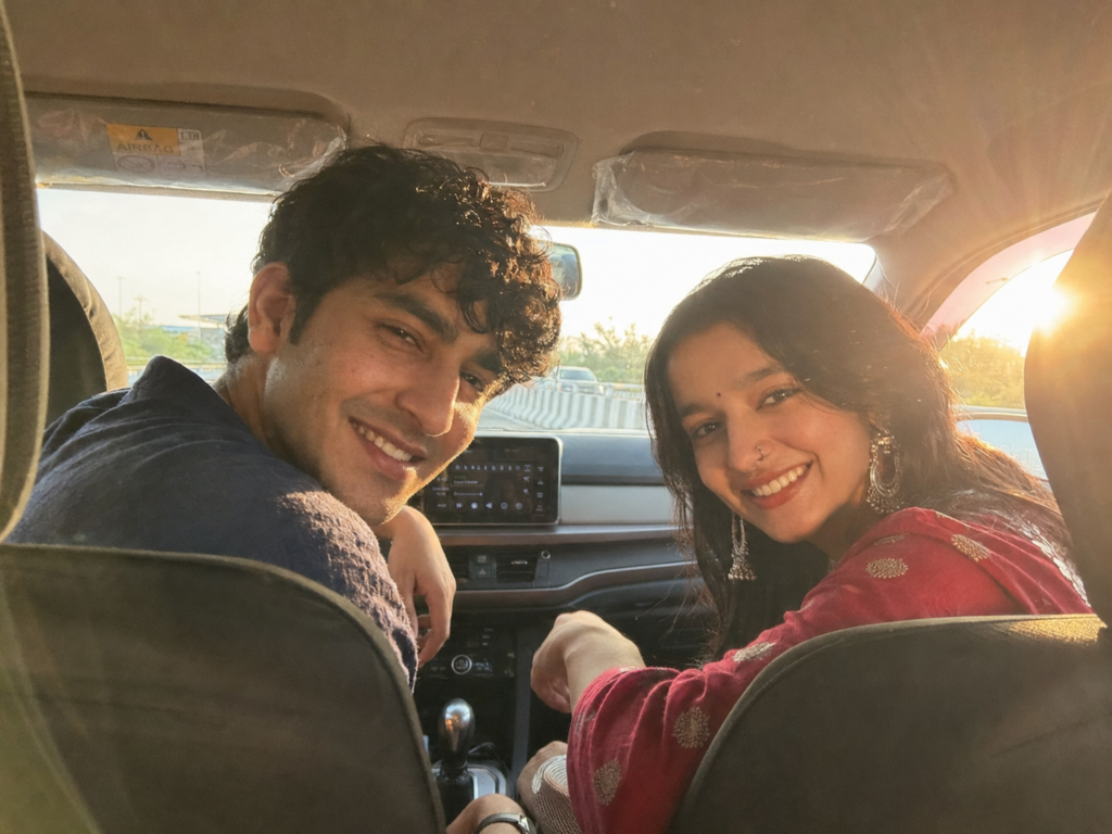 Couple laughing in the front seats of a car with sun flare through the windshield