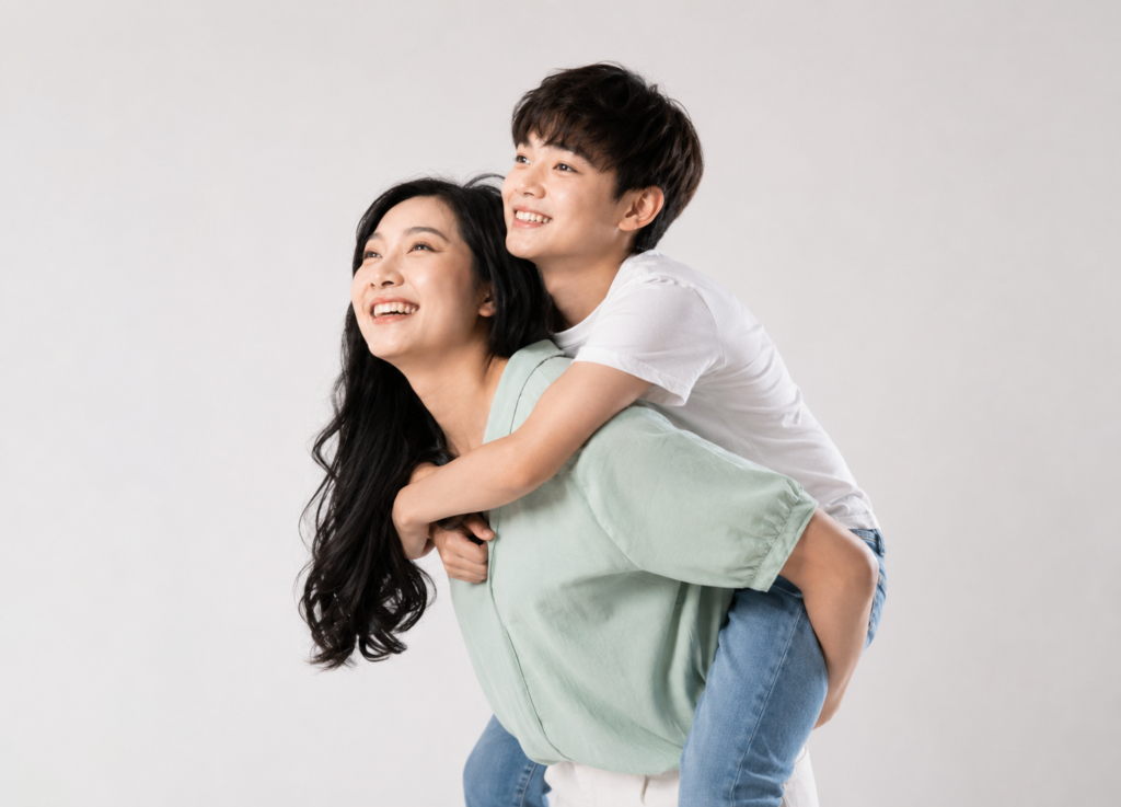 Present-day mother and adult son recreating the pose of an old childhood photo
