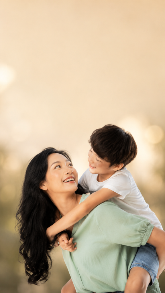 Vertical story portrait of a mother and son looking at each other with space above