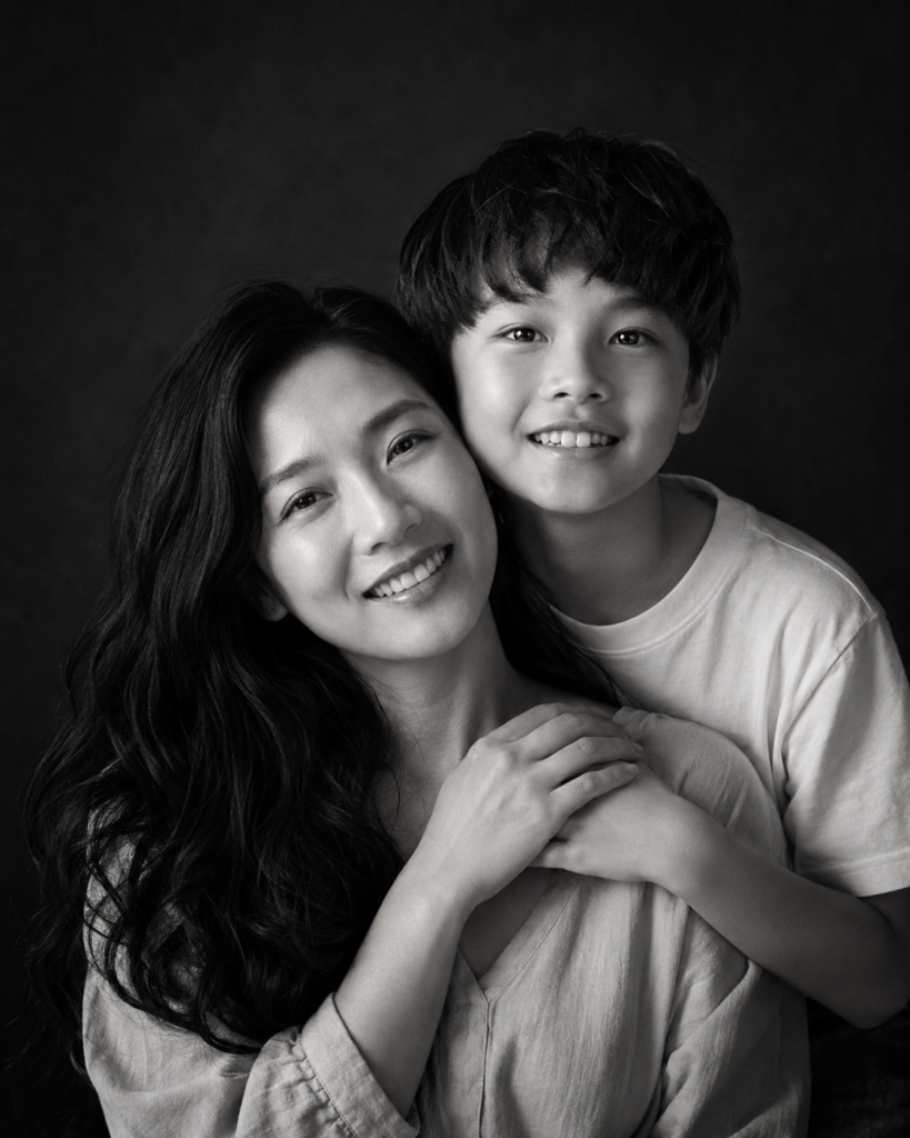 Fine-art black and white portrait of a mother and son with joined hands