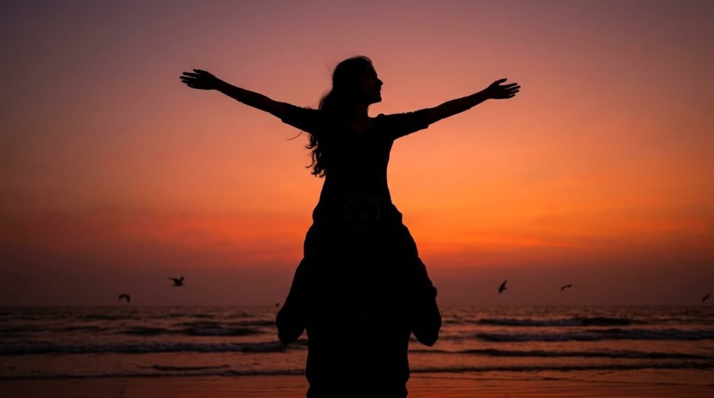 Playful romantic couple in silhouette on a beach at sunset