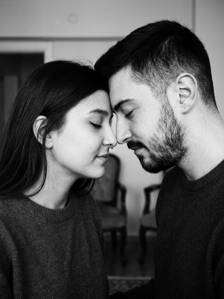 Black-and-white portrait of a couple touching foreheads with eyes closed