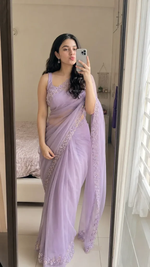 Woman taking a full-body mirror selfie in a lilac organza saree