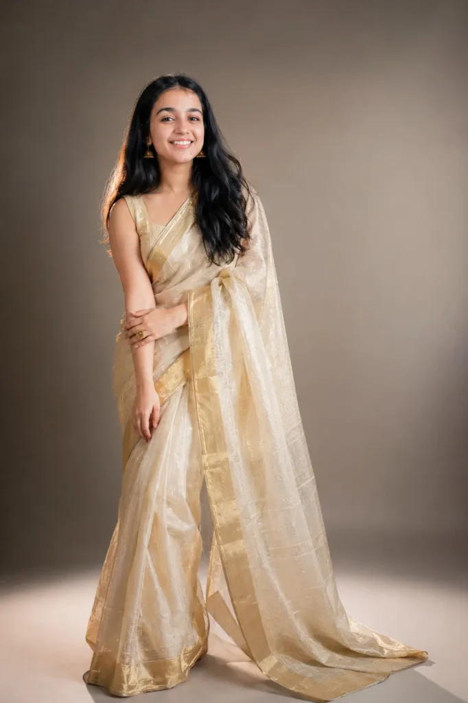 Woman in an ivory-and-gold tissue saree posed for a premium fashion editorial
