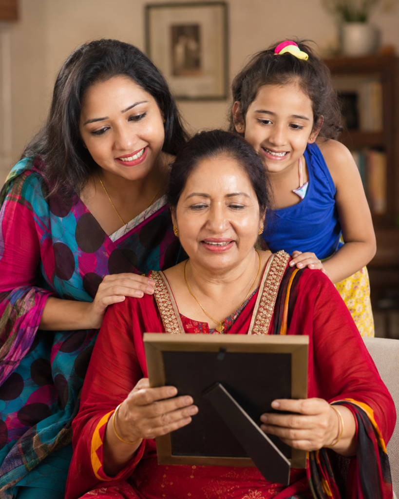 Grandmother holding a framed photo with her daughter and granddaughter beside her