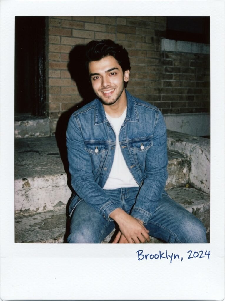 Man sitting casually on a stoop in a Polaroid-style portrait