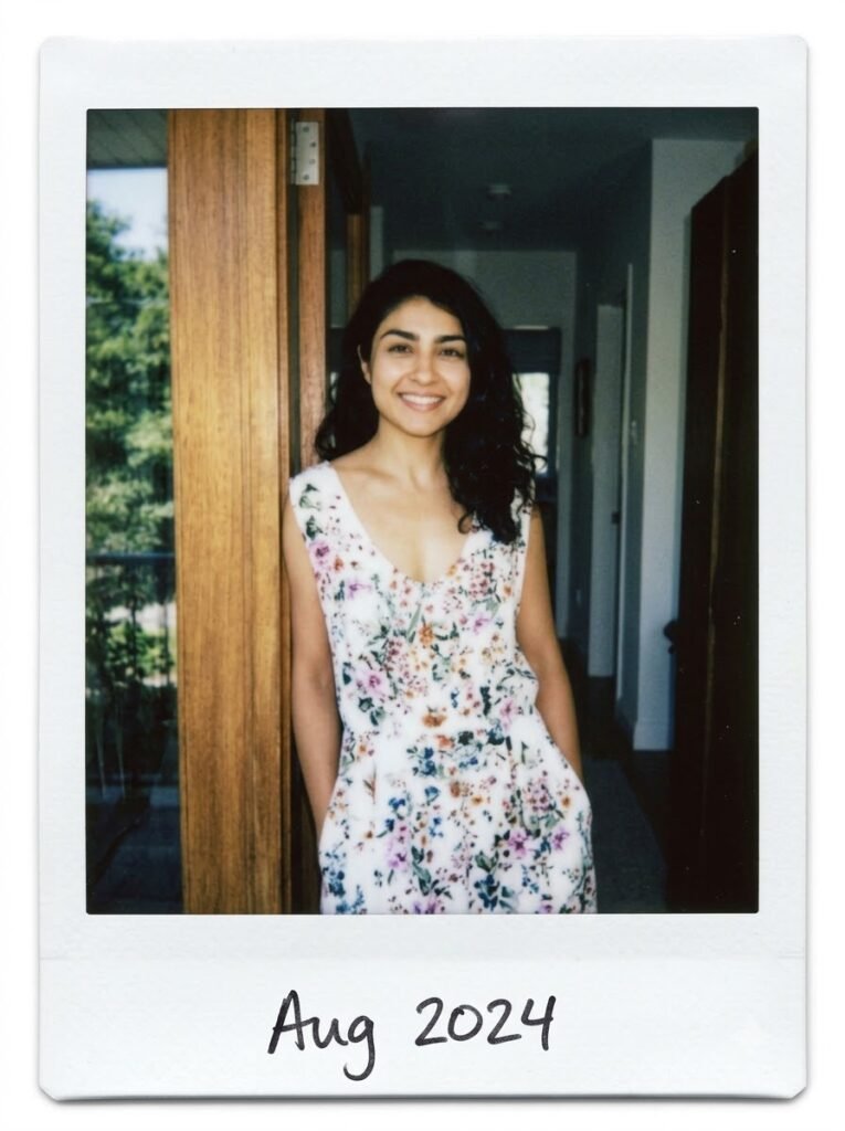 Woman standing in a doorway in a candid Polaroid-style portrait